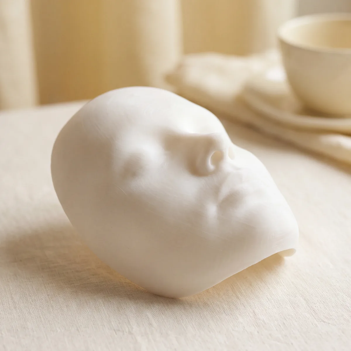 Weisses 3D-Modell eines Gesichts auf hellem Grund, illustratives Motiv
