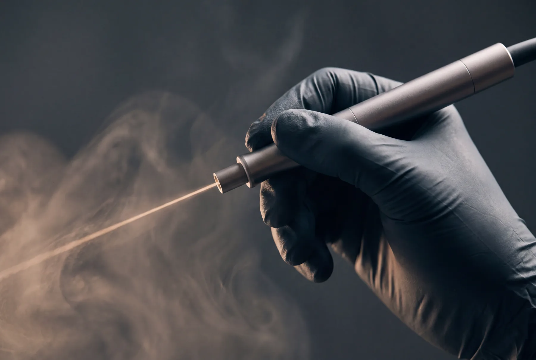 Laser-Handstück mit feinem Lichtstrahl, illustratives Motiv